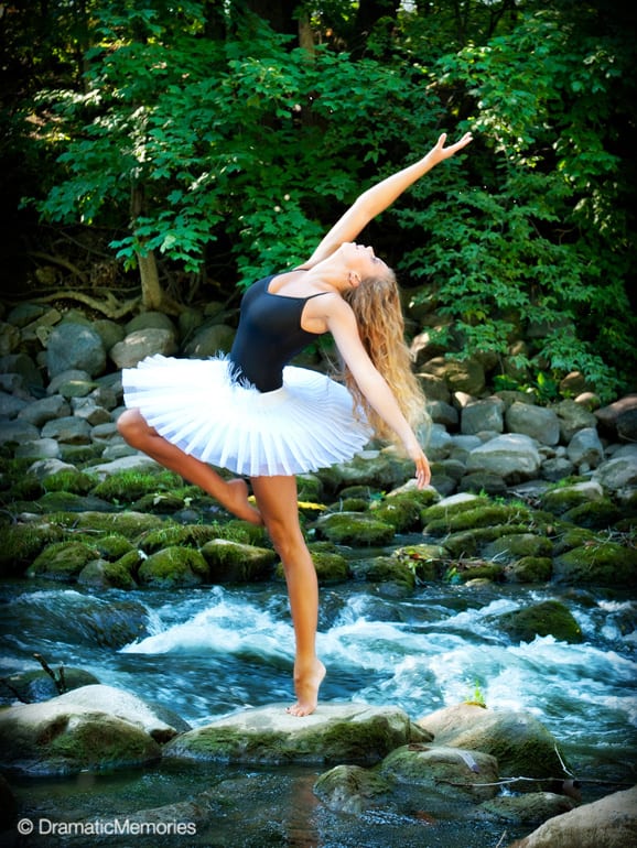 dancer posing on a rock in the middle of river rapids