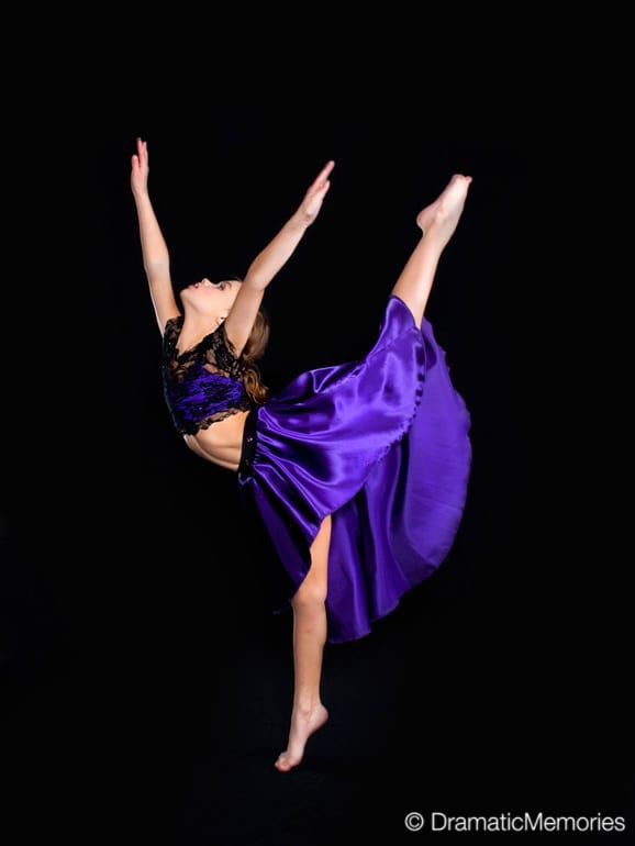 young girl dancer in a purple dress posing